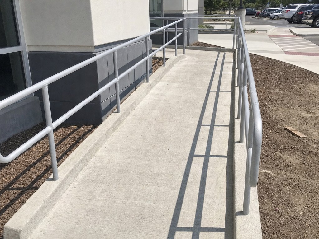 Concrete ADA access ramp with handrails at a Stockton commercial building